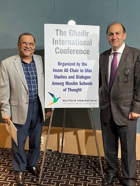 Dr. Kamaly and friend in front of conference sign
