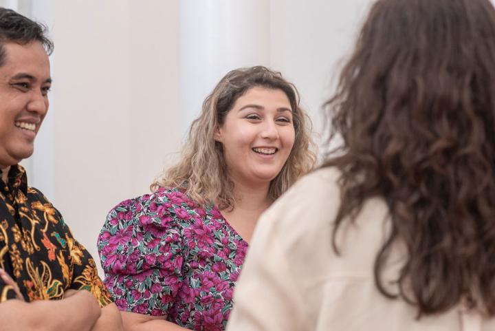 Group of three smiling students chatting